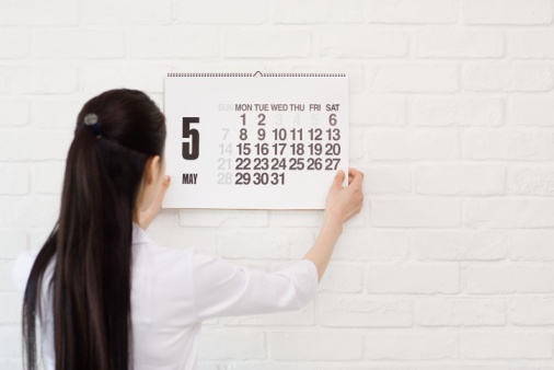 Woman hanging calendar on wall